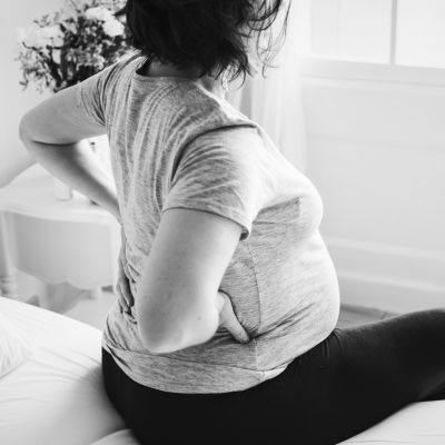 A pregnant woman sitting on a bed